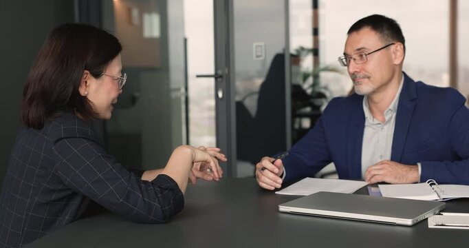 Client listens business manager explaining service terms, review agreement details, clarify conditions, negotiate responsibilities, and prepare for signing contract. Deal, office consultation meeting