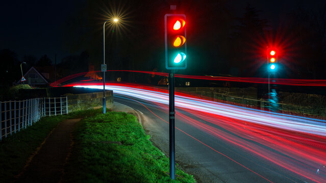 Night intersection with traffic lights and long exposure light trails
