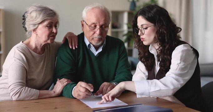Senior 70s couple closing deal and buying insurance services, confirming terms and completing agreement, signing acquisition contract and testament documents during meeting with professional advisor