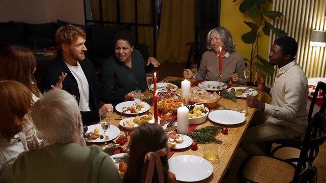 Family and guests dance and sing while sitting at the table