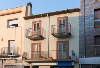 European house facade with metal balconies and window shutters © Sergey