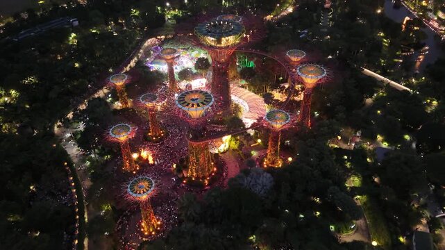 Singapore by Night &ndash; 4K aerial drone footage of marina bay sands, city skyline, skyscrapers, luxury hotels, gardens by the bay, garden Rhapsody, dome and river illuminated in financial district (CBD).