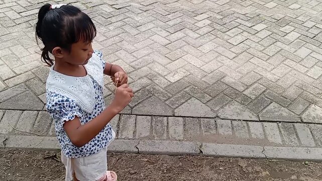 Close-up footage of little girl observing plant details, reflecting eco-conscious curiosity and intentional learning.