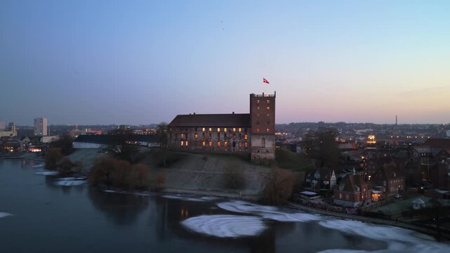 Peaceful afternoon aerial of Koldinghus castle with light ice on lake