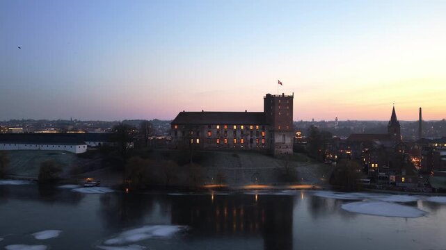 Aerial establishing shot of Koldinghus castle and surrounding lake, Denmark
