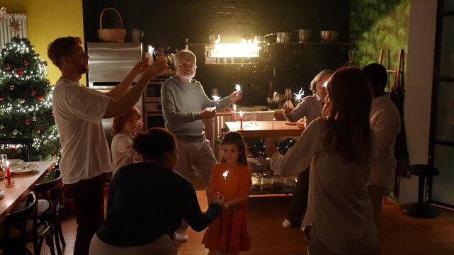 Family and guests dance around granddaughter in center of circle while female guest gives her sparkler