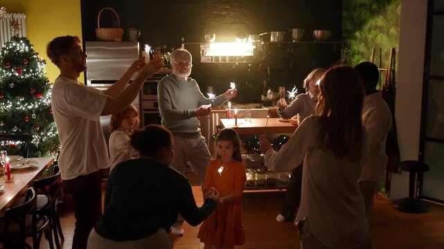 Family and guests dance around granddaughter in center of circle while female guest gives her sparkler