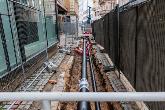 City Street Construction With Exposed Pipeline and Trenches Passing Through Urban Sidewalks