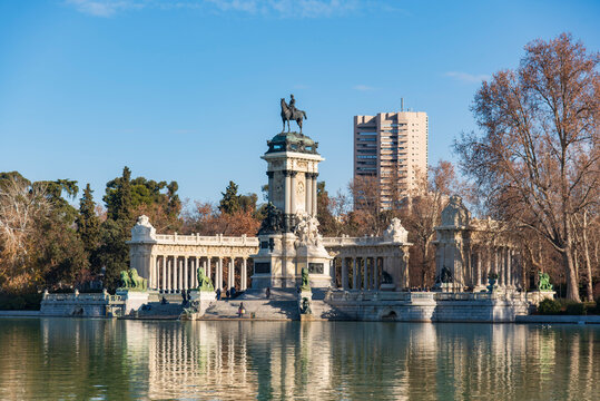 Monument to Alfonso XII at El Retiro Park in Madrid, Spain, neoclassical colonnade and equestrian statue reflected in the lake on a clear day