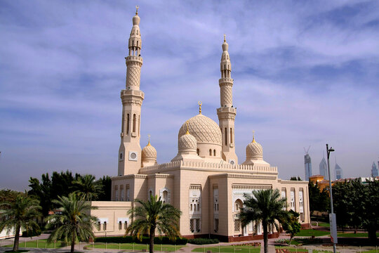Exterior view of the landmark Jumeirah Mosque in Dubai featuring traditional Fatimid-style architecture with white stone and two towering minarets.
