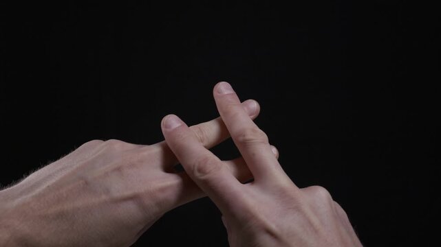 Two hands interlace fingers to create a hashtag symbol on an isolated black background. Concept of social media, digital communication, trending topics, online marketing, and community.