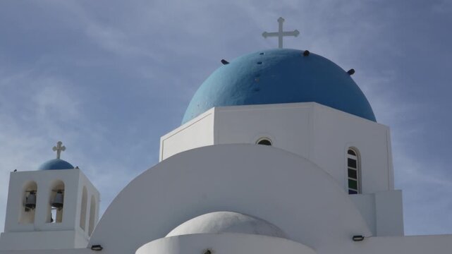 Iconic blue dome and whitewashed Greek Orthodox church structure in Oia (Apano Meria), Santorini, Greece