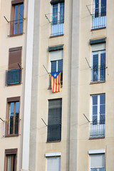Obraz premium Fachada de edificio residencial en Barcelona con bandera independentista catalana en el balcón 