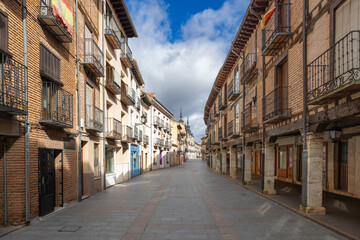 Naklejka premium Burgo de osma old town street with traditional architecture and flags