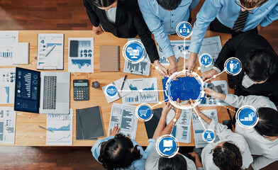 A top view of a diverse group engaged in a collaborative business meeting, analyzing data and...