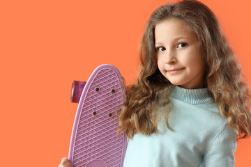 Adorable little girl with skateboard on orange background, closeup © Pixel-Shot