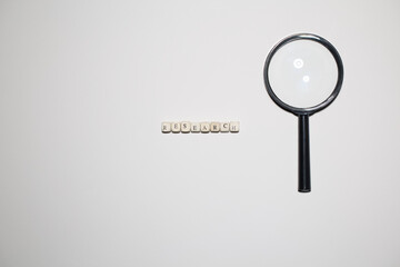 Magnifying glass positioned beside the word research on white background. Symbol of scrutiny,...