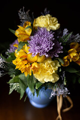 Naklejka premium Elegant purple and yellow flower bouquet on dark background with copy space