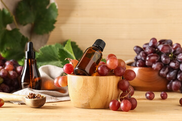 Bottles of cosmetic grape seed oil on wooden background
