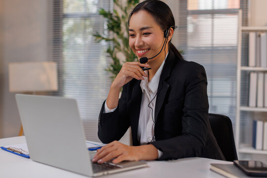 Beautiful asian female operator working laptop and call center agent in the office. Call center customer service. Customer crm and help or support.
