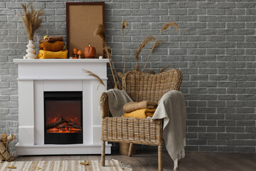 Fototapeta premium Stylish interior of modern room with fireplace and clean warm clothes