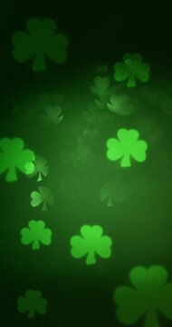 Soft glittering lights in the shape of a three leaf clover. Bokeh in a shamrock shape fading and glowing for a glittering green or St Patricks Day background.