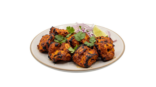 Tandoori chicken tikka pieces on a plate with red onion, cilantro, and lime wedge, isolated on white background