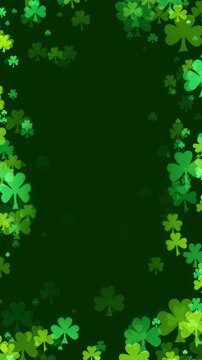St Patricks day background with a frame of shamrocks in various greens floating towards center. Clover leaf particles forming a border for a green background to celebrate St Patrick day.