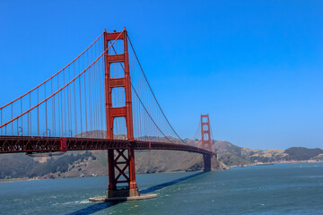 Obraz premium The bridge is surrounded by water and mountains, creating a beautiful