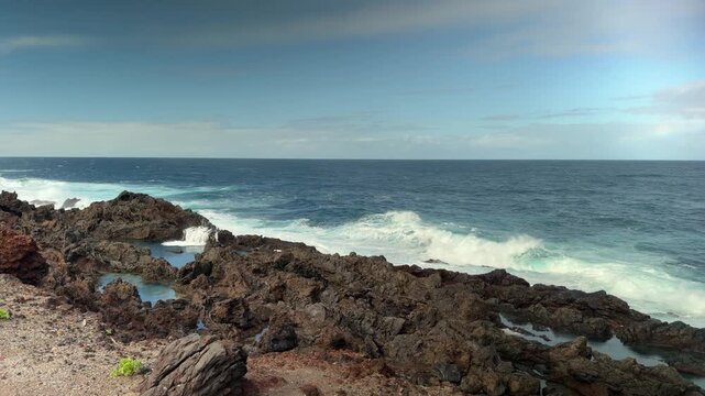 Rugged Tenerife coast with waves at Faro de La Laja, peaceful scene