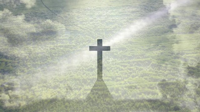 Dark cross standing centered as slanted sunbeam brightening and mist gathering, creating bold halo