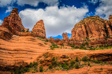 A rocky mountain range with a few trees and a blue sky