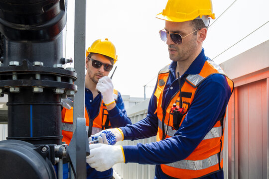 Cooling tower on rooftop. Industry HVAC system. Caucasian male engineer or technician maintenance team and repair of cooling tower on rooftop of building, using handyman tools.
