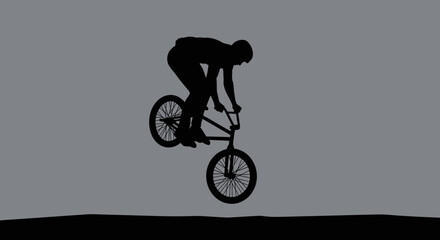 Naklejka premium BMX rider silhouette performing a jump trick against a grey background