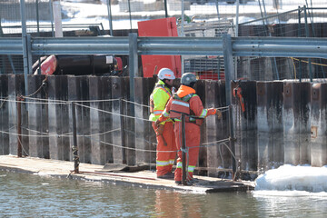 Workers and trucks and factory at a Uranium Processing plant.  © Janet