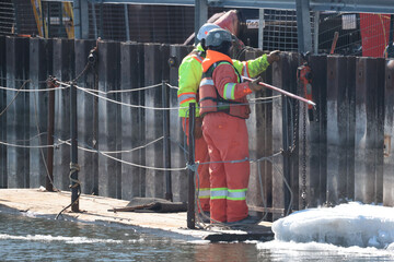 Workers and trucks and factory at a Uranium Processing plant.  © Janet