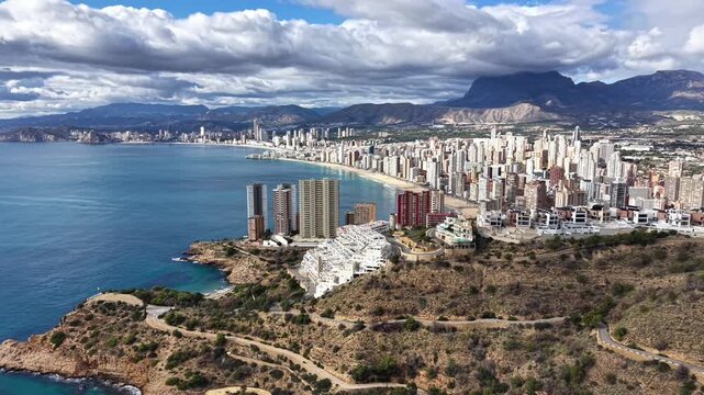 Aerial Beachfront Towers Along Curved Bay With Turquoise Water, Sandy Shore, Rocky Headland, Cluster