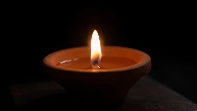 Earthen Oil Lamp with Flickering Flame Against Dark Backdrop Warm Glow Light Brightness Candle