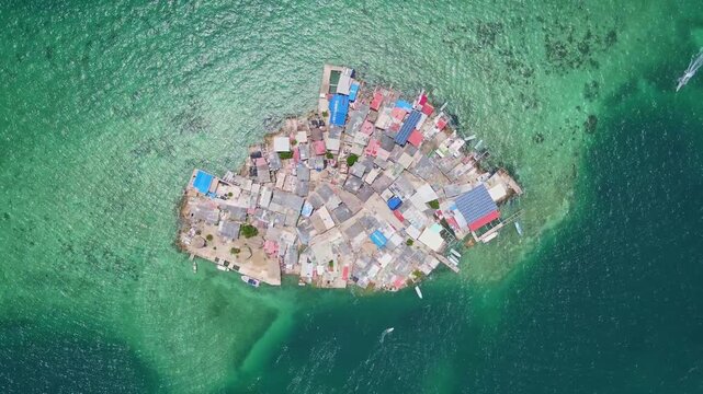 Aerial view of colorful houses on a small island surrounded by clear water.