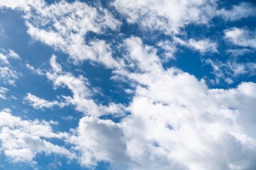 Obraz premium A serene blue sky with fluffy white clouds. This image serves as a perfect background or design element, evoking feelings of peace and tranquility in various creative projects.