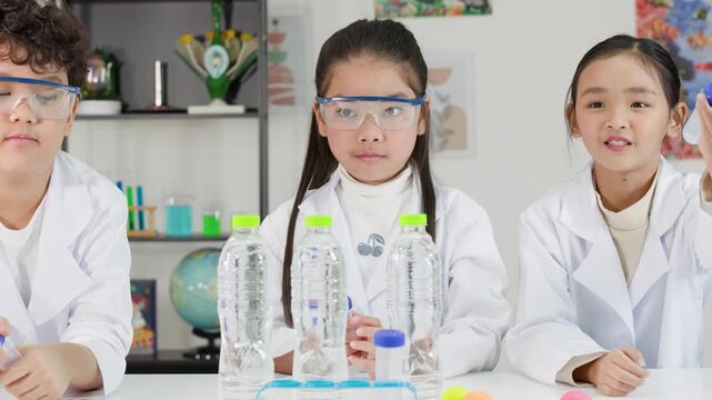 Asian Children in Lab Coats Conducting Bernoulli's Principle Science Experiment