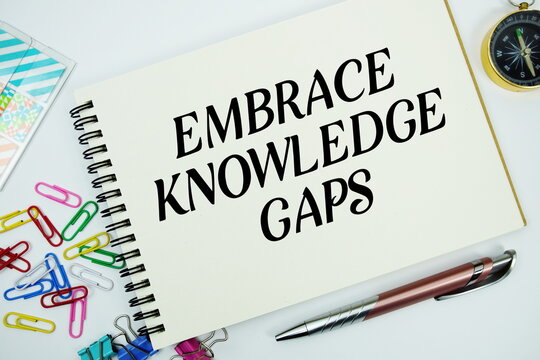 Embrace Knowledge Gaps text message written on notepad with stationery flat lay on white background