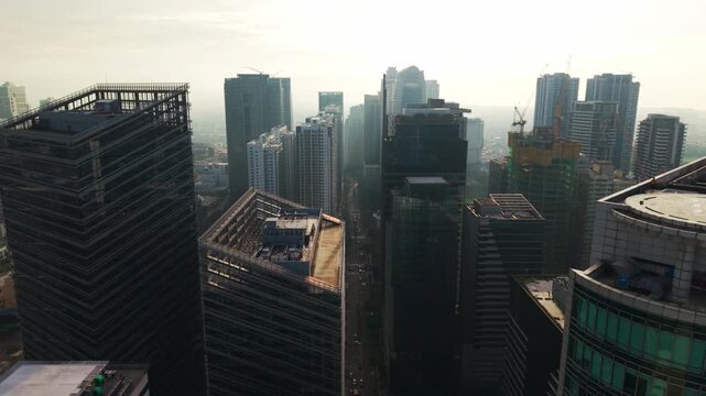 Aerial pullback above BGC towers in warm golden dawn light, Metro Manila