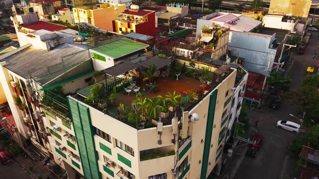 Cinematic orbit around tropical rooftop garden in sunrise glow, Pio del Pilar