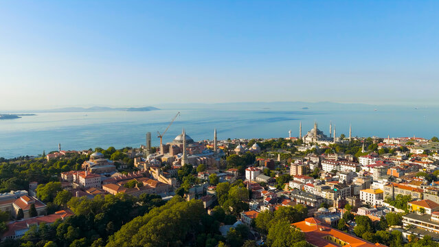 Istanbul, Turkey. Drone flyaway from Hagia Sophia to panoramic view with Blue Mosque and Sultanahmet Square rooftops and sea. Aerial View