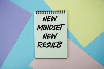 Fototapeta premium New Mindset New Results text written on notepad flat lay on multicolor pastel background
