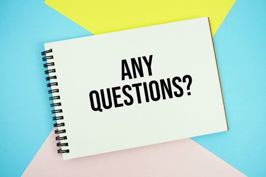 Any Questions? text written on notepad flat lay on multicolor pastel background