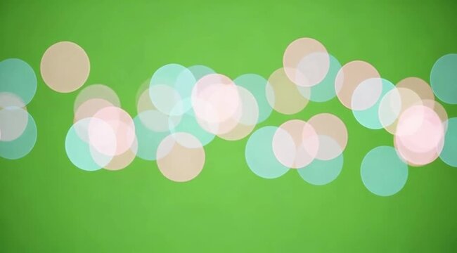 A collection of soft, out-of-focus bokeh circles in pastel pinks and blues, drifting across the frame. The background is a solid