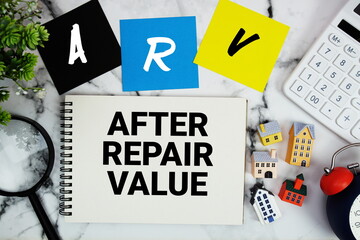 ARV After Repair Value text written on notepad with house model, magnifying glass, calculator and alarm clock on marble background © may1985