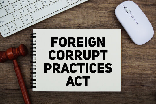 FCPA Foreign Corrupt Practices Act text written on notepad with gavel and keyboard on wooden background